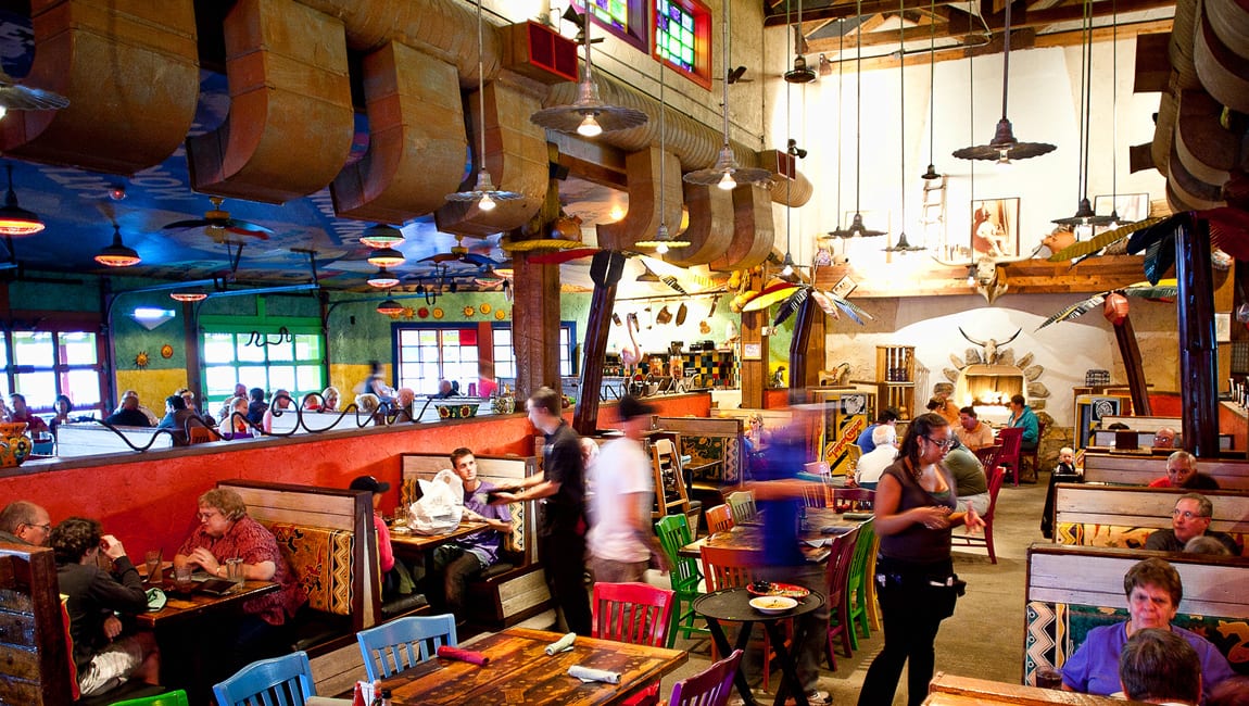 a large, colorful restaurant dining area with many tables and booths
